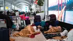 Penumpang yang terdampar menunggu di bandara Istanbul, di mana penerbangan dibatalkan karena badai salju dan hujan salju lebat, di Istanbul, Turki, pada 25 Januari 2022. Penutupan salah satu bandara tersibuk di Eropa ini akibat hantaman badai salju yang menghambat operasional. (Yasin AKGUL/AFP)