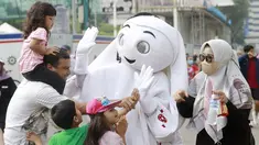Sejumlah anak didampingi orang tuanya ttampak antusias menyapa maskot Piala Dunia 2022, La'eeb, saat Car Free Day (CFD) di kawasan Sudirman, Jakarta, Minggu (06/11/2022). (Bola.com/M iqbal Ichsan)