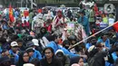 Pedagang asongan berjualan di tengah-tengah aksi unjuk rasa di kawasan Patung Kuda, Jakarta, Selasa (10/11/2020). Sejumlah pedagang mencoba peruntungan saat massa gabungan dari berbagai organisasi buruh dan mahasiswa berunjuk rasa menolak Omnibus Law UU Cipta Kerja. (Liputan6.com/Helmi Fithriansyah)