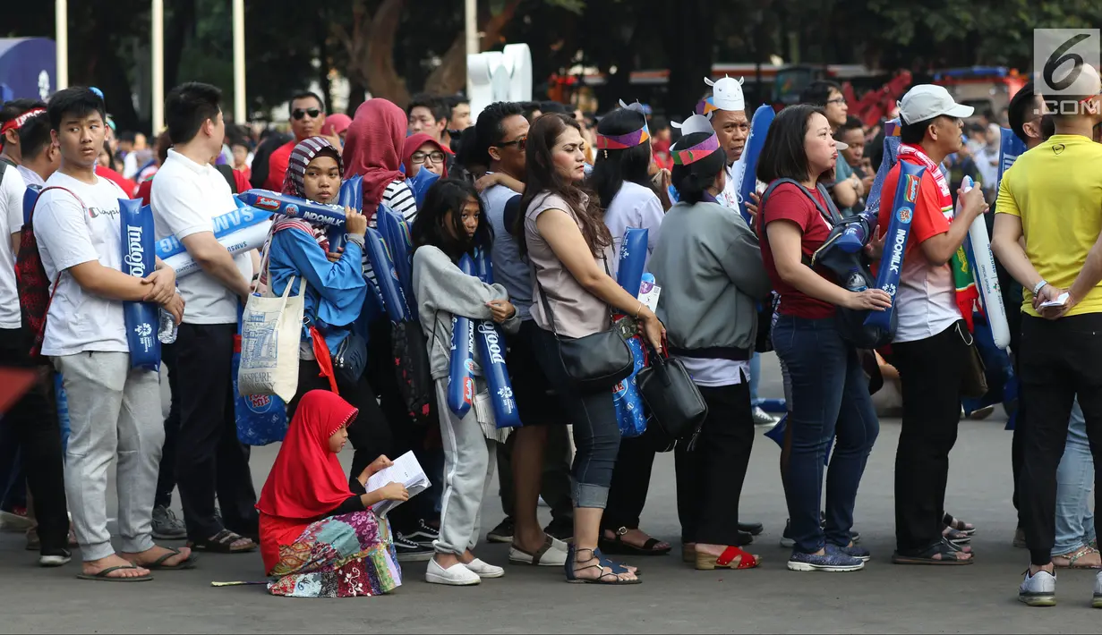 Calon penonton antre untuk masuk menyaksikan laga final bulu tangkis beregu putra di Istora Senayan Jakarta, Rabu (22/8). Laga final bulu tangkis beregu putra mempertemukan Indonesia melawan China. (Liputan6.com/Helmi Fithriansyah)