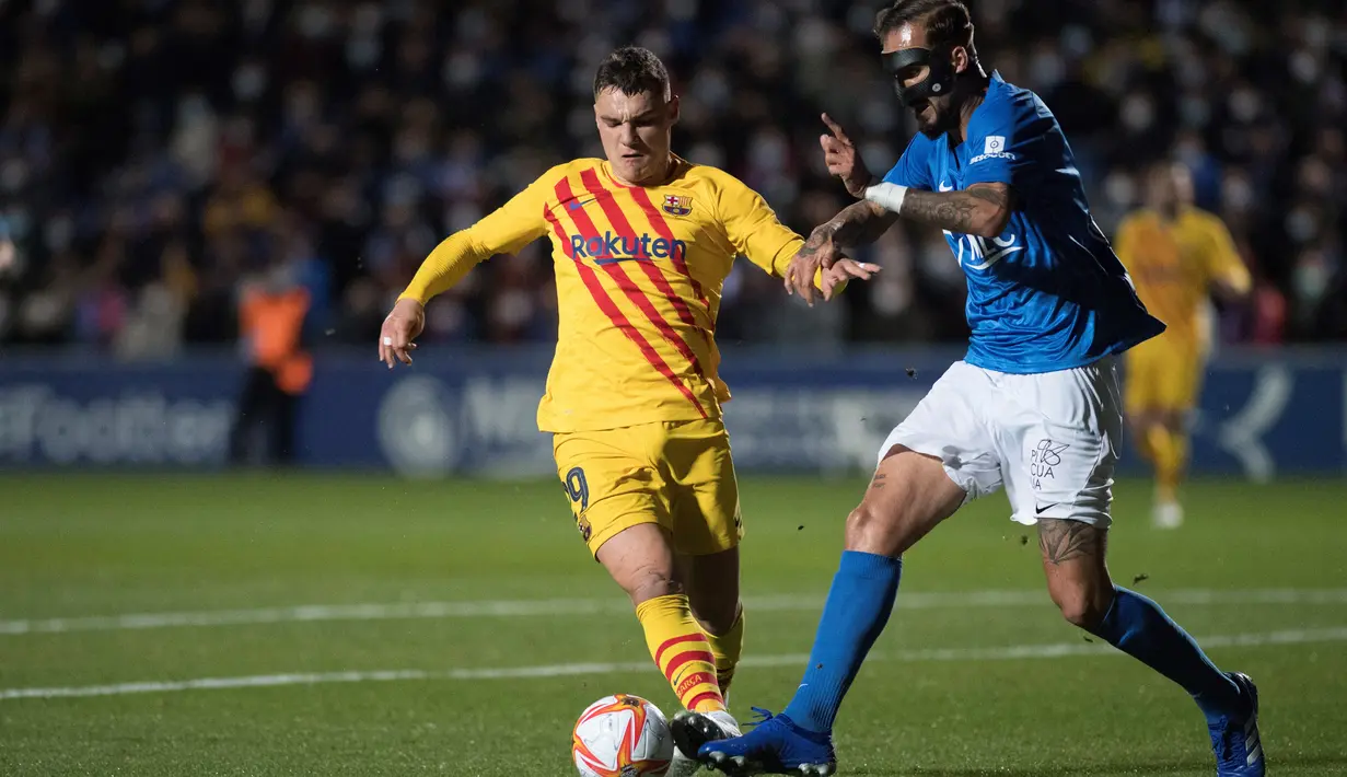 Gelandang Barcelona Ferran Jutgla (kiri) berebut bola dengan bek Linares Deportivo, Josema pada babak 32 Besar Copa del Rey di Estadio Linarejos, Kamis (6/1/2022) dini hari WIB. Barcelona susah payah menang 2-1 atas tim divisi 3 Linares Deportivo. (JORGE GUERRERO / AFP)