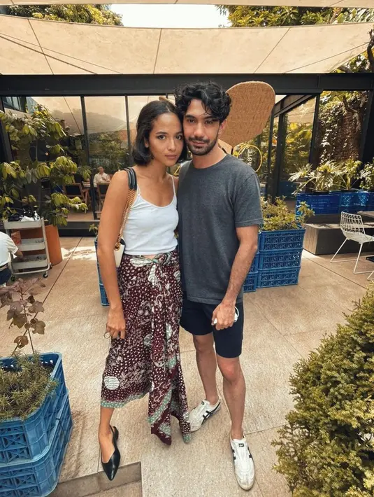 Berpose berdua dengan Reza Rahadian, Putri Marino tampak cantik dengan tank top putih polos yang dipadunya dengan kain bernuansa cokelat keunguan bercorak floral. Foto: Instagram.