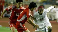Rochy Putiray (putih) saat memperkuat Timnas Indonesia melawan Timnas China di fase grup Piala Asia 2004. (AFP/Frederic Brown)