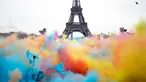 Sejumlah orang melempar bubuk berwarna saat merayakan akhir perlombaan Color Run 2018 di depan Menara Eiffel di Paris, Prancis (15/4). Dengan acara ini sekitar Menara Eiffel terlihat berwarna-warni. (AP/Thibault Camus)