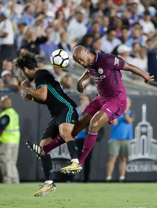 Gelandang Real Madrid, Isco berebut bola udara dengan bek Manchester City, Vincent Kompany pada pertandingan ICC di Los Angeles Memorial Coliseum, Kamis (27/7). City menang atas Madrid dengan skor 4-1. (AP Photo/Jae C. Hong)