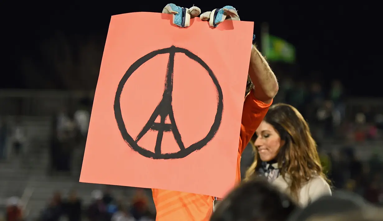 Kiper Ottawa Fury, Romuald Peiser memegang logo menara Eifel tanda turut berduka atas tragedi Perancis, usai laga Final NASL Championship di Hempstead, New York, Minggu(15/11/2015).  (AFP Photo/Don Emmert)