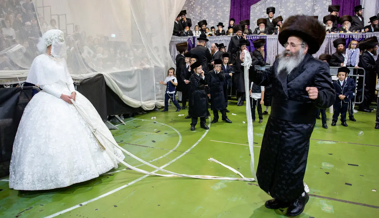 Pengantin Yahudi ultra-ortodoks Hannah Halbershtam memasuki bagian pria saat melangsungkan upacara pernikahan di kota ultra-ortodoks Bnei Brak, Israel, Selasa (20/8/2019. Dalam acara ini keluarga dan para rabi terhormat diundang untuk menari di depan pengantin wanita. (AP Photo/Oded Balilty)