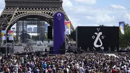 Penonton menyaksikan Woodkid tampil di atas panggung di zona penggemar Olimpiade di Taman Trocadero di depan Menara Eiffel di Paris, Minggu (8/8/2021). Paris akan menjadi tuan rumah Olimpiade Musim Panas berikutnya pada tahun 2024. (AP Photo/Francois Mori)