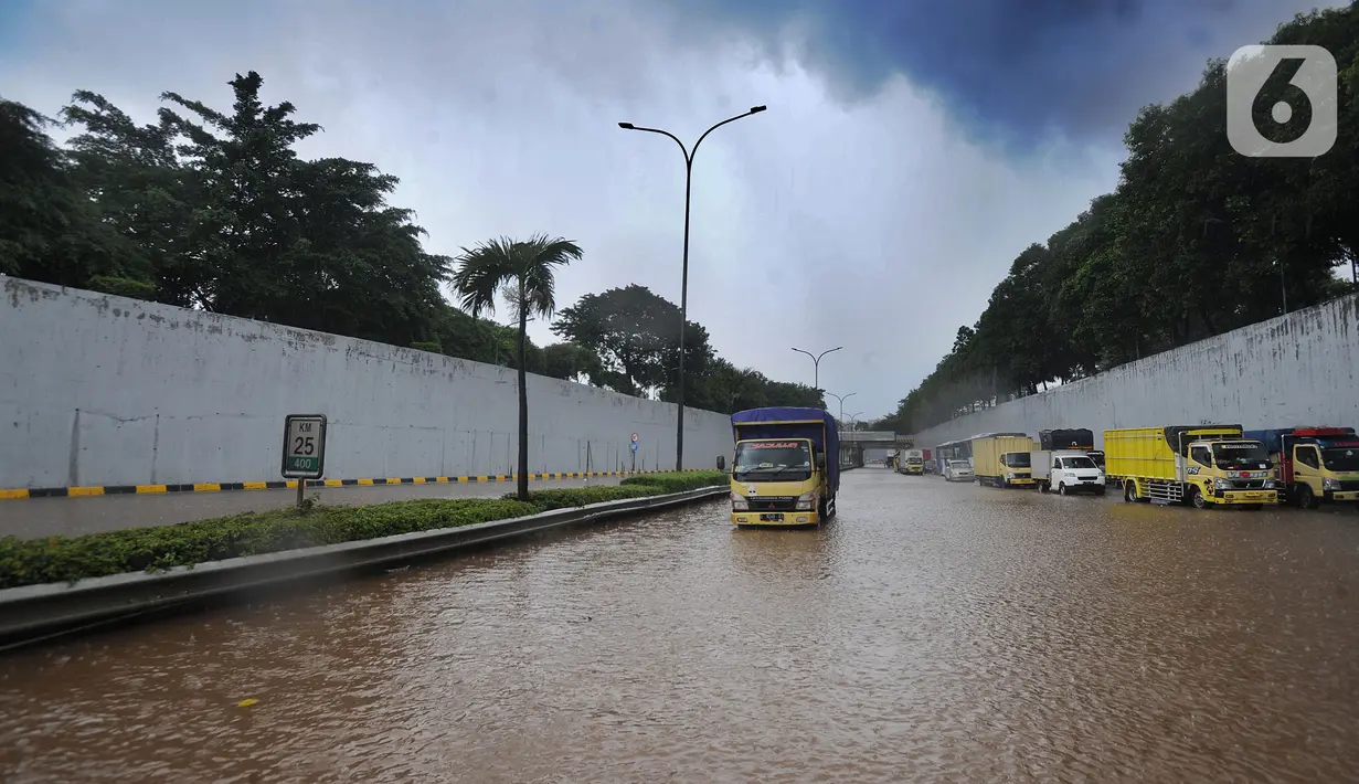 Sebuah truk melintasi banjir yang menggenangi Jalan Tol JORR di kawasan TB Simatupang, Jakarta Selatan, Sabtu (20/2/2021). Banjir terjadi akibat luapan Kali Serua yang berada di pinggir jalan tol. (merdeka.com/Arie Basuki)
