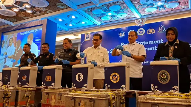 Jajaran pimpinan Bank Indonesia dan kepolisian secara simbolis memasukkan uang rupiah palsu ke dalam wadah pembuangan mesin pencacah. Pemusnahan ini mengikuti prosedur ketat. (Liputan6.com/Arief)