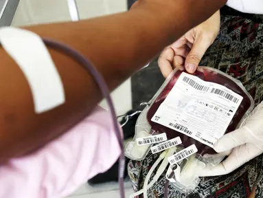 Warga mendonorkan darahnya di rumah sakit saat acara "Give Blood Give Love" untuk merayakan Hari Valentine di Phnom Penh, Kamboja (14/2/2016). Acara ini dipelopori oleh Badan transfusi darah pusat nasional di Kamboja. (Reuters/Samrang Pring)
