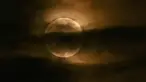 Bulan terlihat melalui awan saat gerhana bulan sebagian di Srinagar, India, Jumat (5/5/2023). Gerhana Bulan Penumbra akan muncul pada Jumat (5/5/) hingga Sabtu (6/5) dinihari. (TAUSEEF MUSTAFA / AFP)