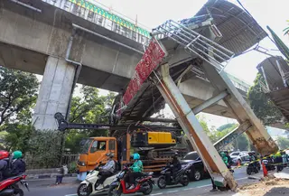 Sebuah truk  truk towing pengangkut alat berat (crane)  tersangkut dan merusak  jembatan penyeberangan orang (JPO) di Jalan Raya Kapten Tendean, Jakarta, Selasa (14/07/2026).