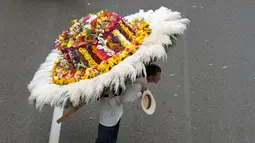 Seorang pria memanggul rangkaian bunga saat digelarnya festival bunga tahunan di Medellin, Kolombia, Minggu (9/8/2015). Festival yang dikenal dengan nama Silleteros Parade ini telah dilangsungkan sejak 1957. (REUTERS/Fredy Builes)