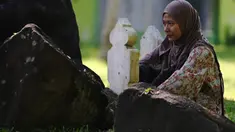 Seorang wanita berdoa untuk kerabat yang kehilangan nyawa dalam tsunami Samudra Hindia 2004 di sebuah kuburan massal di Banda Aceh pada 26 Desember 2024. (CHAIDEER MAHYUDDIN/AFP)