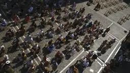 Orang-orang berkumpul di alun-alun Plaza del Ayuntamiento dan menjaga jarak untuk mencegah penyebaran COVID-19 selama festival music flamenco pada hari musim panas, di Pamplona, Spanyol utara, Kamis (26/8/2021).  (AP Photo/Alvaro Barrientos)