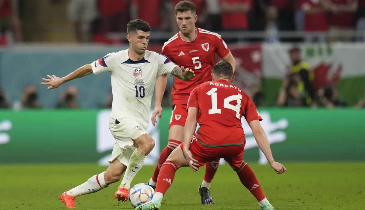 <p>Gelandang Amerika Serikat, Christian Pulisic berusaha melewati pemain Wales, Connor Roberts pada pertandingan grup B Piala Dunia 2022 Qatar di Stadion Ahmad Bin Ali di Doha, Qatar, Selasa (22/11/2022). Dengan hasil tersebut Wales berada di posisi kedua klasemen Grup B dengan satu poin, dan Amerika Serikat di peringkat ketiga. Sementara Inggris memimpin dengan tiga poin dan Iran di posisi buncit. (AP Photo/Aijaz Rahi)</p>