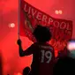 Seorang pendukung Liverpool merayakan gelar juara Liga Premier di luar Stadion Anfield, Kamis (25/6/2020). Trofi juara Liga Primer musim 2019-2020 Trofi juara Liga Primer musim 2019-2020 tersebut dimenangkan Liverpool setelah Manchester City takluk 1-2 dari Chelsea. (AP/Jon Super)