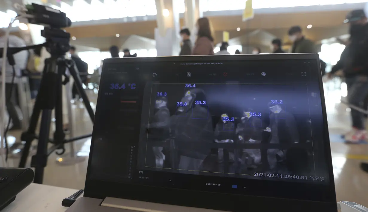 Monitor kamera termal menunjukkan suhu tubuh penumpang saat mereka antre pada malam liburan Tahun Baru Imlek di terminal penerbangan domestik bandara Gimpo di Seoul, Kamis (11/2/2021). Liburan Tahun Baru Imlek tahun ini di Korea Selatan berlangsung dari Kamis hingga Minggu. (AP Photo/Ahn Young-joon)