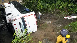 Kondisi bus yang jatuh di jalan penghubung Medellin dan Bogota dekat San Luis, Provinsi Antiokia, Kolombia, 27 Desember 2021. Tujuh orang, termasuk seorang wanita hamil, tewas dan 20 lainnya luka-luka ketika sebuah bus terjun ke jurang. (Fredy BUILES/AFP)