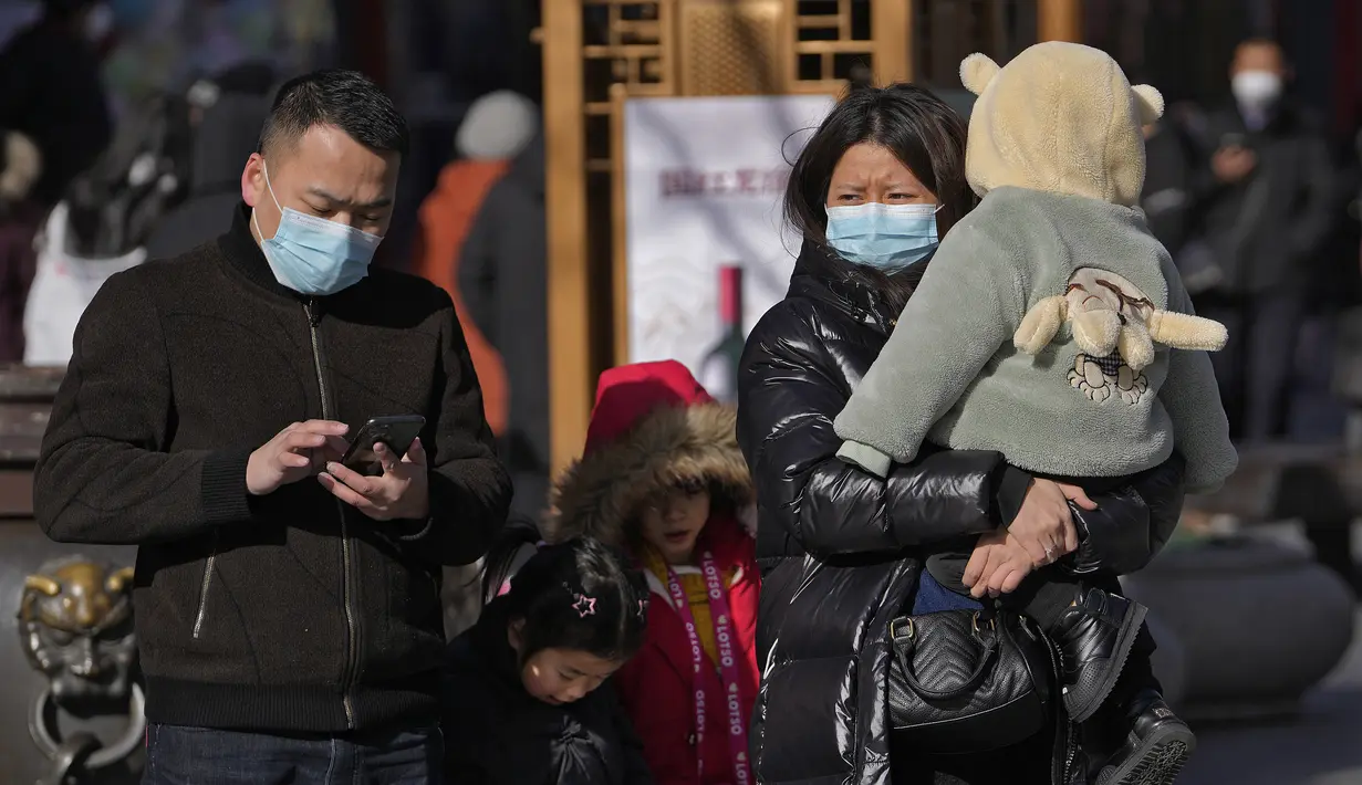 Keluarga mengunjungi jalan perbelanjaan pejalan kaki Qianmen, tempat wisata populer di Beijing, Selasa (17/1/2023). Penurunan populasi tersebut merupakan perubahan bersejarah yang diprediksi bakal menjadi awal mula periode panjang penurunan jumlah warga China. Nantinya, bakal berimbas pada perekonomian dunia. (AP Photo/Andy Wong)