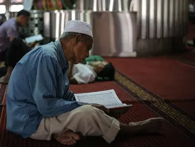 Umat muslim membaca kita suci Alquran di Masjid Istiqlal, Jakarta, Kamis (18/6/2015). Kegiatan ini dilakukan untuk beristirahat sambil menanti waktu berbuka puasa. (Liputan6.com/Faizal Fanani)