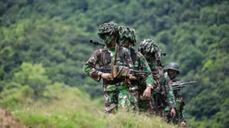 Sejumlah prajurit TNI dari batalyon infantri Raider 112 berjalan membawa berbagai senjata selama latihan menembak di Mata Ie, Aceh Besar, Aceh, Selasa (11/6/2019). Latihan menembak ini untuk memelihara dan meningkatkan kemampuan prajurit Raider.  (AFP Photo/Chaideer Mahyuddin)