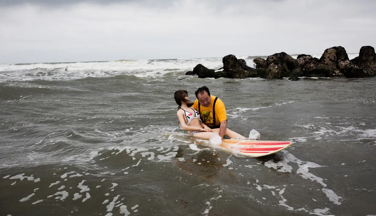 Senji saat mengajak Saori bermain di pantai, Jepang (April 2017). Lebih dari 7 tahun Senji hidup bersama Saori padahal, Senji telah memiliki istri dan dua orang anak. (AFP Photo/ Behrouz MEHRI)