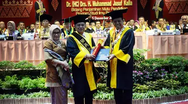 Mantan Wakil Presiden Jusuf Kalla (kiri) didampingi sang istri, Mufidah Kalla berjabat tangan dengan Rektor Universitas Negeri Padang (UNP) Ganefri (kanan) saat penganugerahan gelar doktor kehormatan (Dr. Honoris Causa), di kampus tersebut di Padang, Kamis (5/12/2019). (FOTO: Tim Media JK)