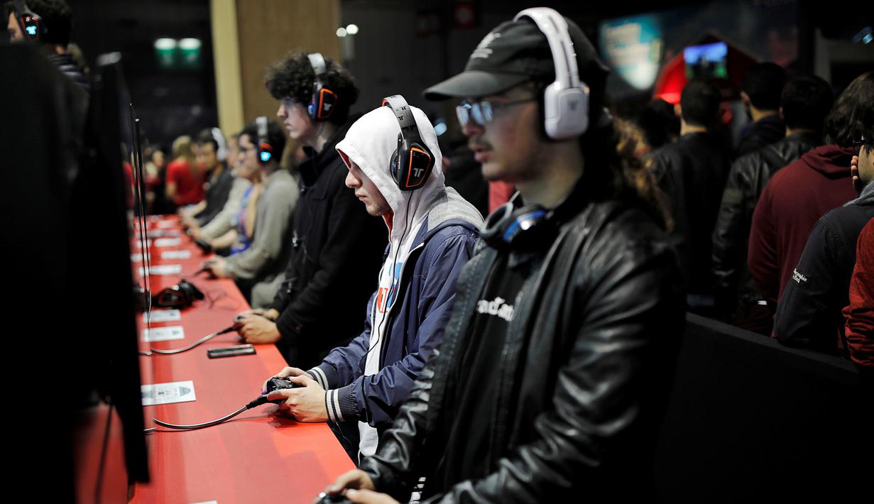 Para Pengunjung terlihat serius memainkan berbagai video game yang ditampilkan dalam acara Paris Games Week di Paris, Prancis (26/10). Paris Games Week diselenggarkan pada 27–31 October. (REUTERS/Benoit Tessier)