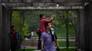 Seorang wanita menggunakan ponselnya berselfie di sebuah taman di Beijing (19/4). Beijing adalah ibu kota Republik Rakyat Tiongkok dan merupakan salah satu kota terpadat di dunia. (AFP Photo/Wang Zhao)