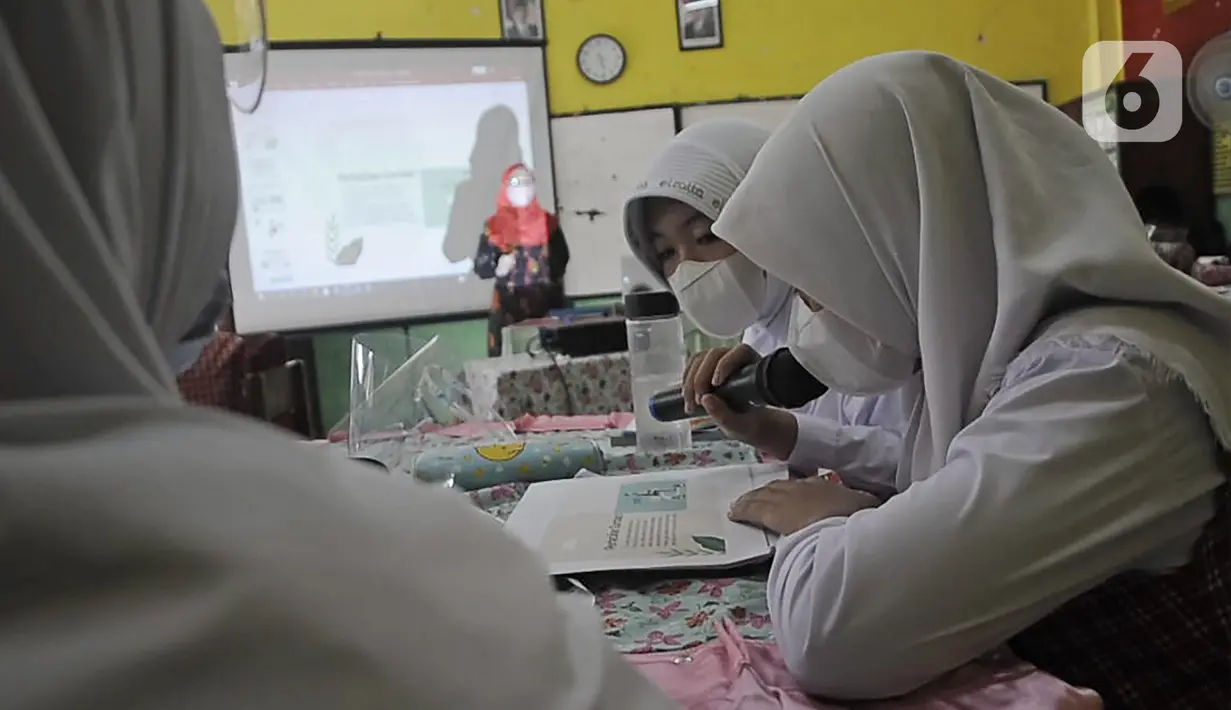 Para murid mengikuti pembelajaran tatap muka (PTM) terbatas di SDN Pisangan Baru 05 Pagi, Jakarta, Senin (8/11/2021). Pembekalan pemahaman protokol kesehatan dilakukan seiring penambahan jumlah sekolah tatap muka terbatas pada masa PPKM Level 1. (merdeka com/Iqbal S. Nugroho)