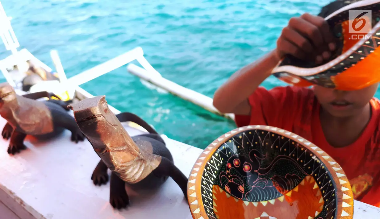 Kerajianan berupa patung komodo dan mangkok dipajang di atas kapal semi pinisi di Pink Beach, Taman Nasional Komodo, Sabtu, (9/10). Kerajinan tersebut, diambil Albin dan Kevin dari warga sekitar Pulau Komodo. (Liputan6.com/Fery Pradolo)