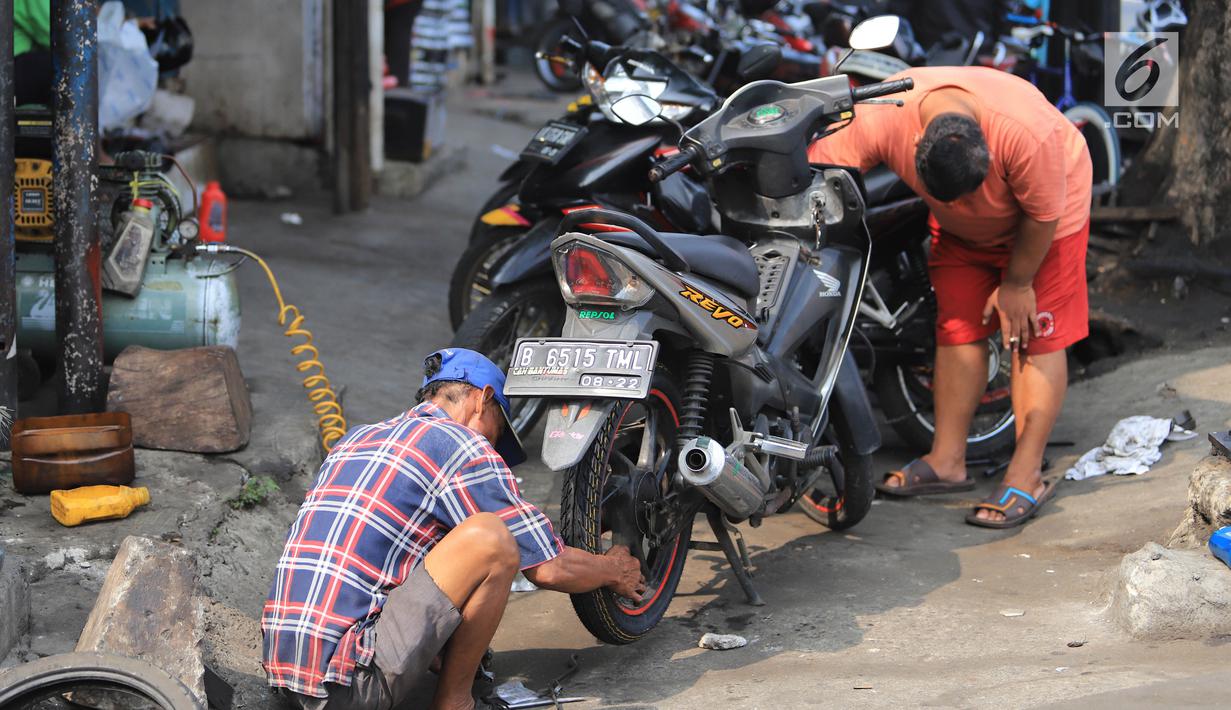 Mekanik mengecek motor pelanggan di sebuah bengkel di Otista, Jakarta, Minggu (10/6). Calon pemudik motor mulai memenuhi bengkel guna menyervis atau mengganti suku cadang kendaraan sebelum digunakan untuk mudik Lebaran. (Liputan6.com/Angga Yuniar)