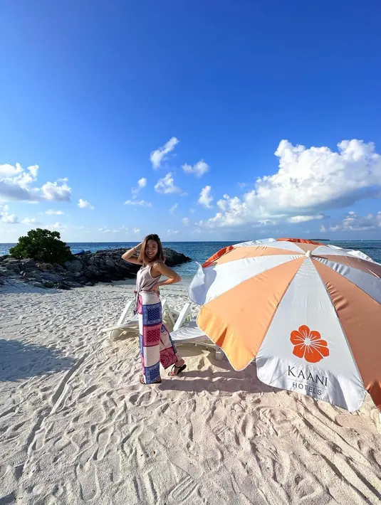 Sleeveless top dan loose pants bermotif bisa jadi inspirasi tampil lebih santun di pantai. [Foto: IG/gisel_la].