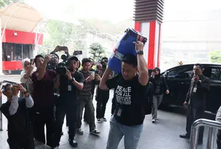 Petugas KPK membawa sebuah tong besar berwarna biru yang disegel dengan tulisan “Dalam Pengawasan KPK” di Gedung Merah Putih KPK, Jakarta Selatan, Jumat (16/10/2026). Tong tersebut dibawa bersamaan dengan kedatangan Bupati Klaten Hamenang Wajar Ismoyo setelah terjaring operasi tangkap tangan (OTT). (officialkpkri)