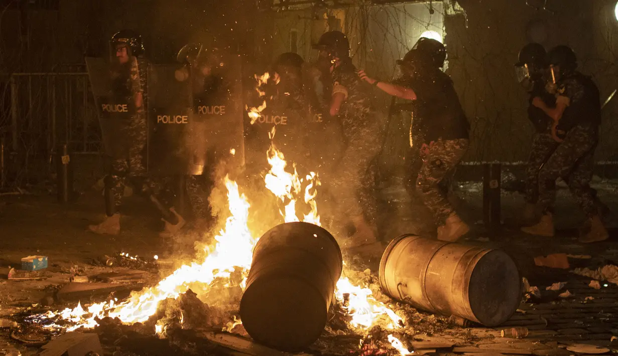 Polisi antihuru-hara bergerak maju untuk mendorong kembali pengunjuk rasa antipemerintah selama protes terhadap elite politik yang telah memerintah negara selama beberapa dekade di Beirut, Lebanon, Jumat (7/8/2020). (AP Photo/Hassan Ammar)