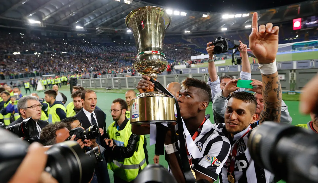 Gelandang Juventus, Paul Pogba mencium piala Coppa Italia usai mengalahkan Lazio di Final Coppa Italia di Olimpico Roma, Italia, Rabu (20/5/2015). Juventus menang 2-1 atas Lazio. (Reuters/Giampiero Sposito)