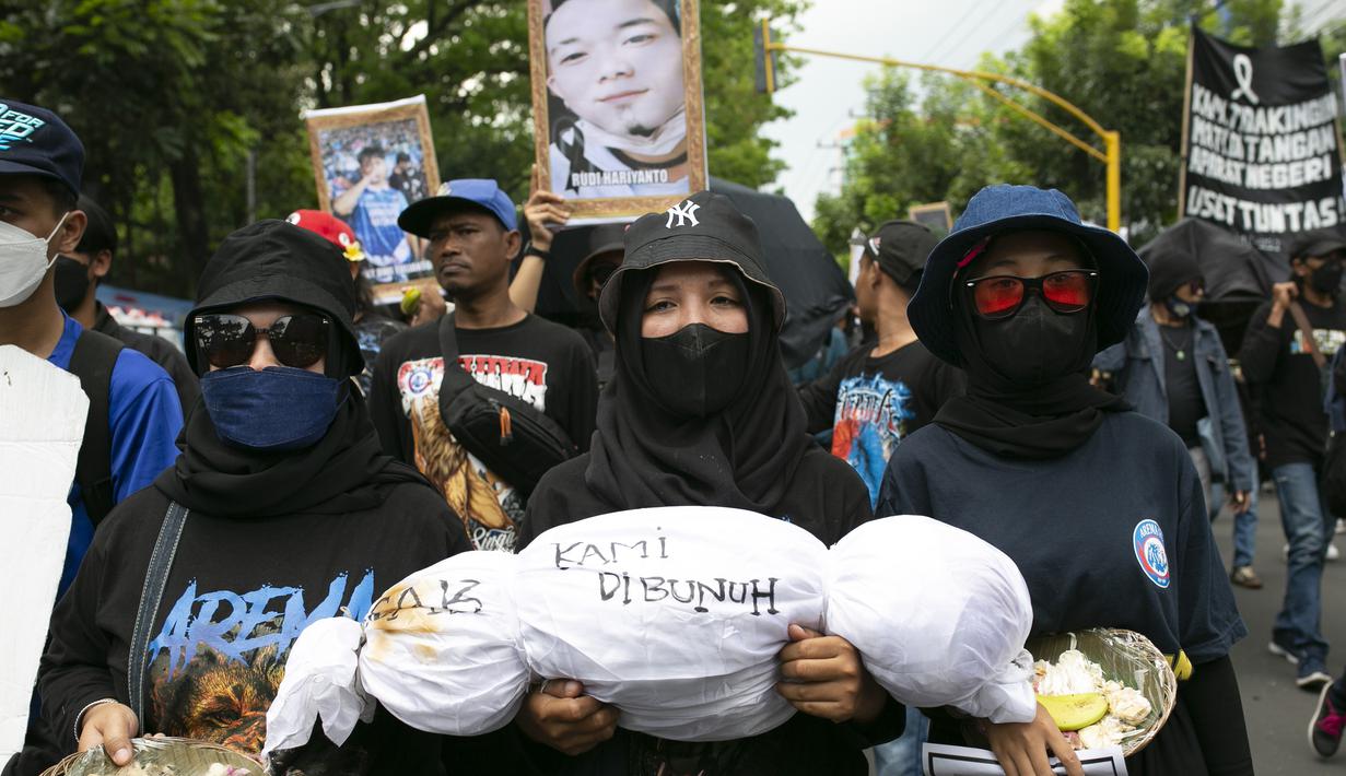 Pengunjuk rasa membawa replika jenazah yang mewakili korban Tragedi Kanjuruhan pada 1 Oktober, di Malang, Jawa Timur, Kamis (10/11/2022). Unjuk rasa yang diikuti ribuan Aremania tersebut menuntut pemerintah dan aparat penegak hukum menangkap serta mengadili seluruh pelaku yang terlibat dalam kasus tersebut. (AP Photo/Rizki Dwi Putra)