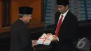 Jokowi menerima berkas yang diikat dengan pita merah putih saat menghadiri rapat paripurna di Dewan Perwakilan Rakyat Daerah (DPRD) DKI Jakarta, Jakarta, Rabu (23/7/14) (Liputan6.com/Herman Zakharia)