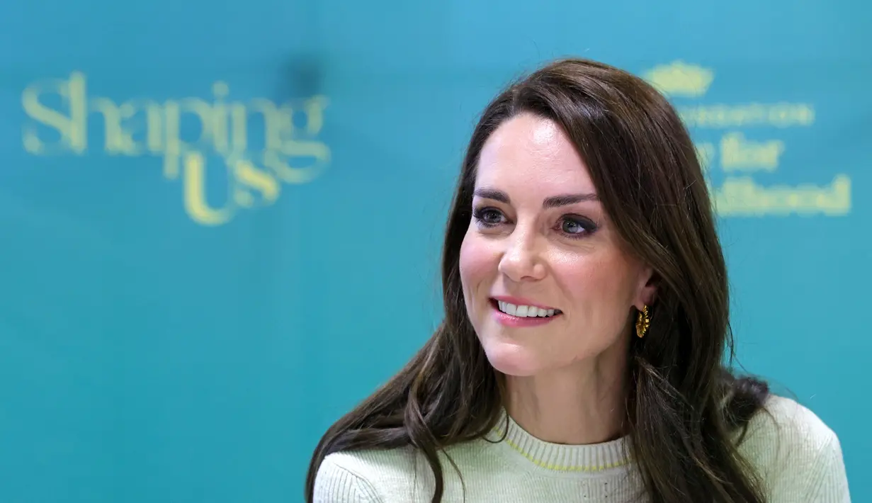 Princess of Wales, Kate Middleton dari Inggris tertawa saat bertemu dengan ara siswa dan staf pada kursus Studi Anak, selama kunjungan ke University of Leeds di Leeds, Inggris utara, pada 31 Januari 2023. Menjaga perhiasannya seminimal mungkin dengan anting-anting emas £74 dari Shyla London, Kate memilih blow-dry yang melenting dan melengkapi pakaiannya dengan tas suede hijau £435 yang serasi dari Manu Atelier. (AFP/Pool/Chris Jackson)