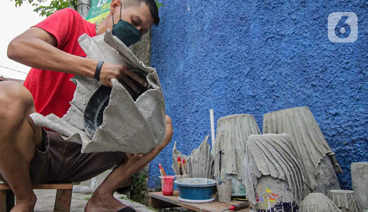 Seorang anak muda menyelesaikan pembuatan pot tanaman berbahan dasar kain bekas di  Cibodas, Kota Tangerang, Minggu (3/10/2021). Para pemuda ini memanfaatkan PPKM untuk membuat Pot tanaman daur ulang yang dipasarkan mulai harga Rp. 30 ribu hingga Rp. 80 ribu. (Liputan6.com/Angga Yuniar)
