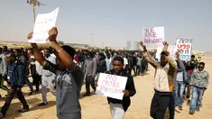 Migran Afrika berkumpul berjalan menuju Penjara Saharonim untuk melakukan aksi di gurun selatan Negev, Israel (22/2). Mereka melakukan aksi protes terkait sembilan orang dari migran Afrika yang dipenjara oleh Israel. (AFP Photo/Menahem Kahana)