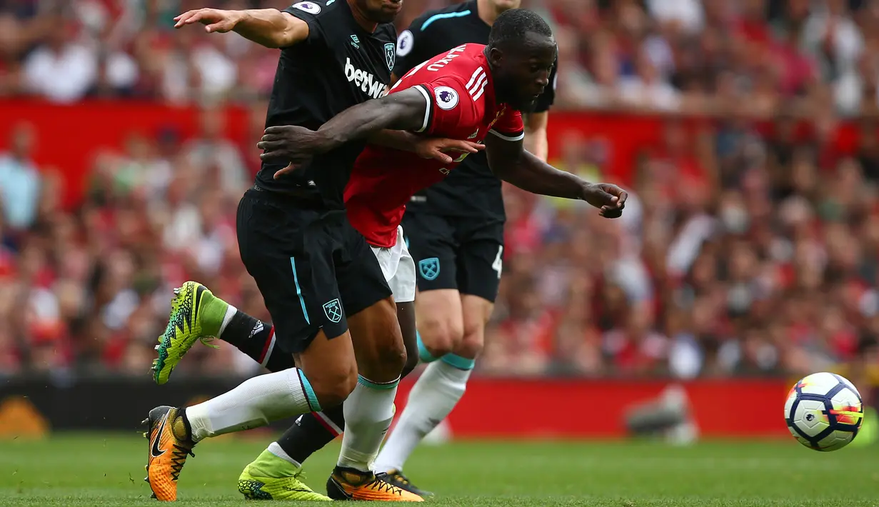 Penyerang MU, Romelu Lukaku berusaha melewati dua pemain West Ham pada pertandingan Liga Inggris di Old Trafford, Manchester, Inggris, (13/8). MU menang telak atas West Ham dengan skor 4-0. (AP Photo/Dave Thompson)