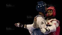 Atlet taekwondo Indonesia, Dinggo Ardian (merah), saat melawan Morrison Samuel, pada final kelas kyorugi -74 kg SEA Games di KLCC, Kuala Lumpur, Minggu (27/8/2017). Kalah di final, Dinggo harus puas meraih perak. (Bola.com/Vitalis Yogi Trisna)