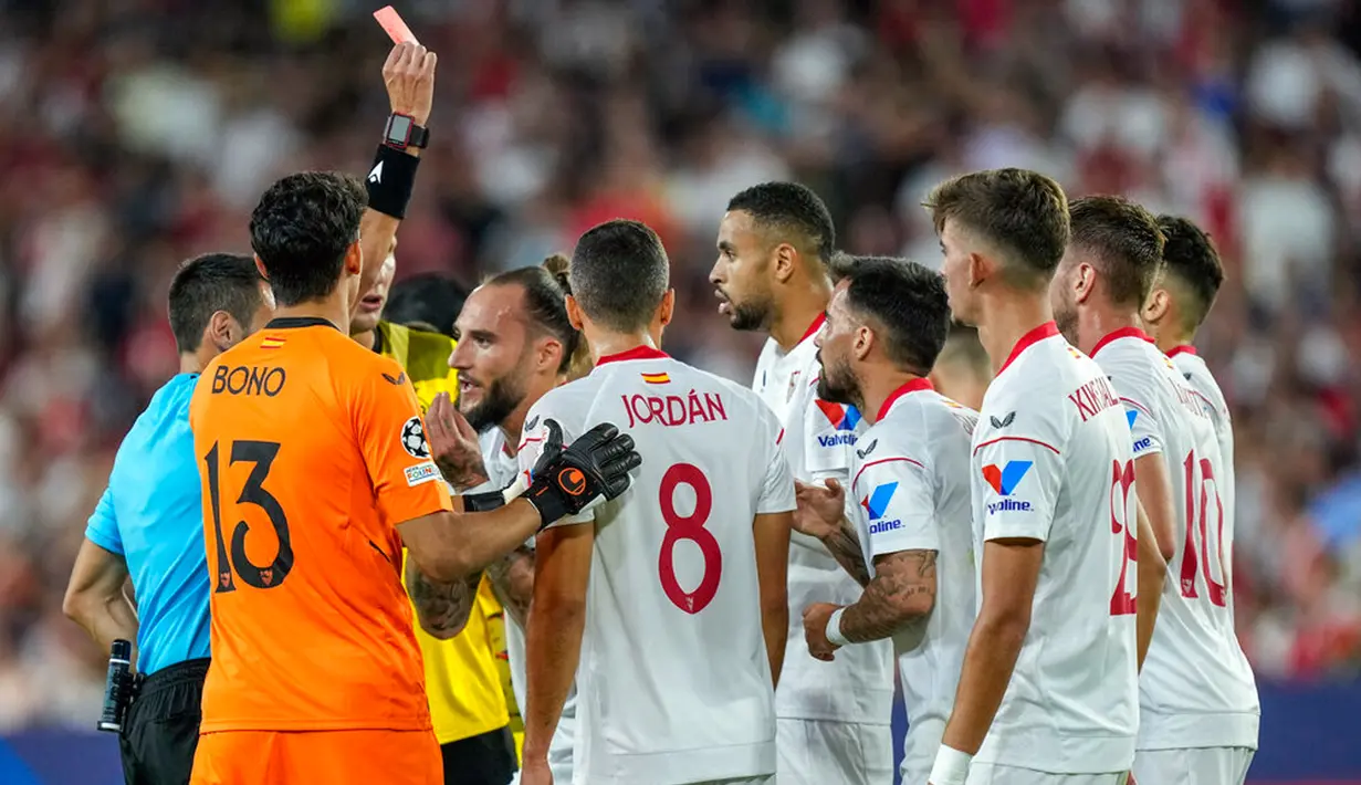 Wasit memberikan kartu merah kepada pemain Sevilla Youssef En-Nesyri (tengah) saat melawan Borussia Dortmund pada pertandingan Grup G Liga Champions di Stadion Ramon Sanchez Pizjuan, Seville, Spanyol, 5 Oktober 2022. Borussia Dortmund menang 4-1. (AP Photo/Jose Breton)