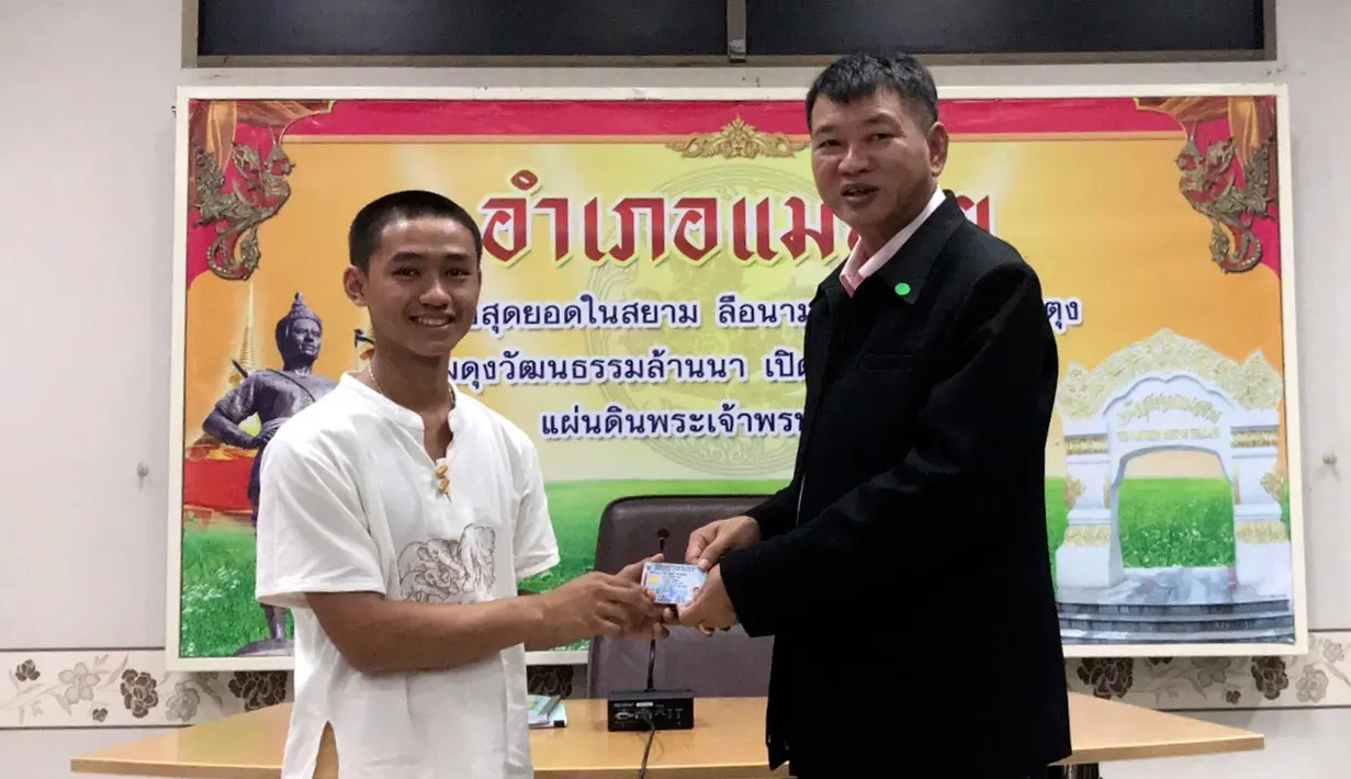 Salah seorang remaja, Adul Samon menerima kartu identitas sebagai warga negara Thailand di distrik Mae Sai, Rabu (8/8). Korban gua Thailand tersebut selama ini hidup tanpa memiliki status kewarganegaraan. (Chiang Rai Public Relations Office via AP)
