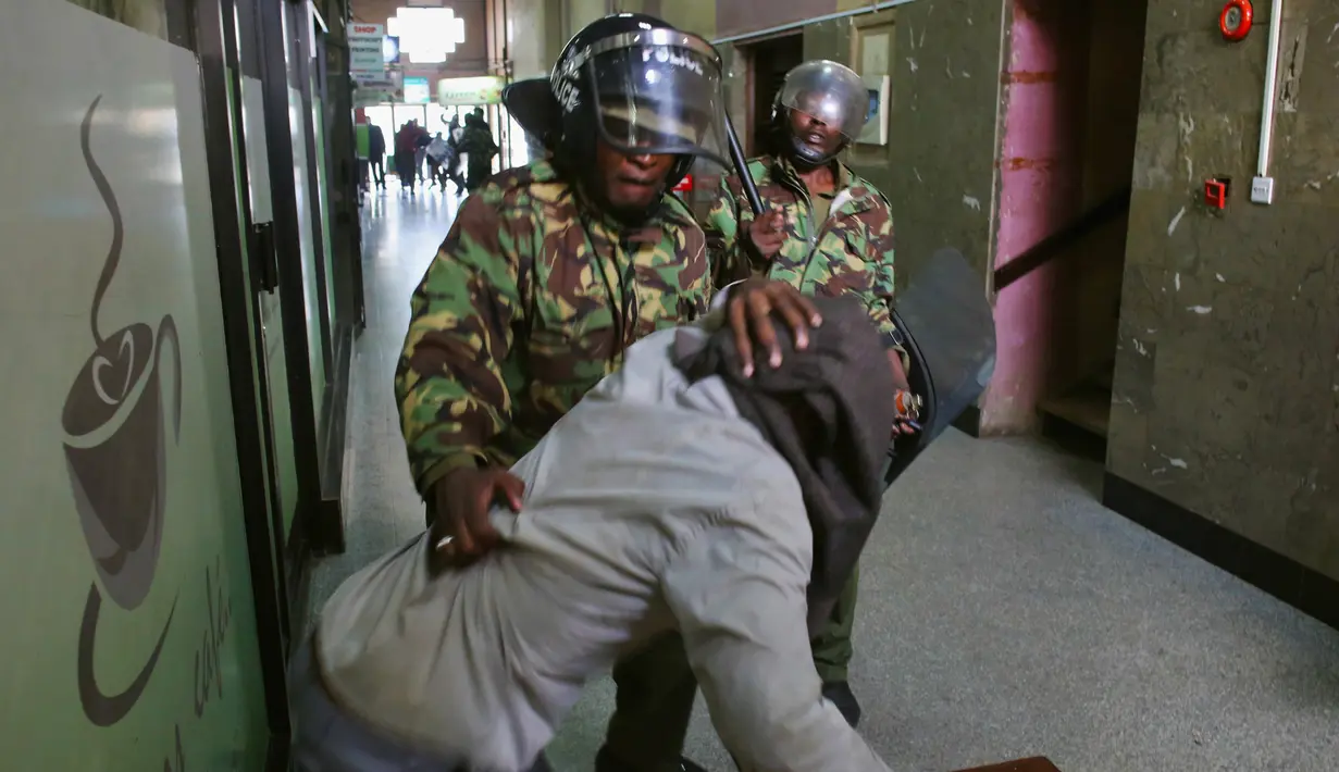 Para Polisi memukuli seorang demonstran di dalam sebuah gedung saat bentrokan di Nairobi, Kenya (16/5). Demonstran menuntut pembubaran otoritas pemilu karena adanya dugaan korupsi. (REUTERS/Goran (REUTERS/Goran Tomasevic)