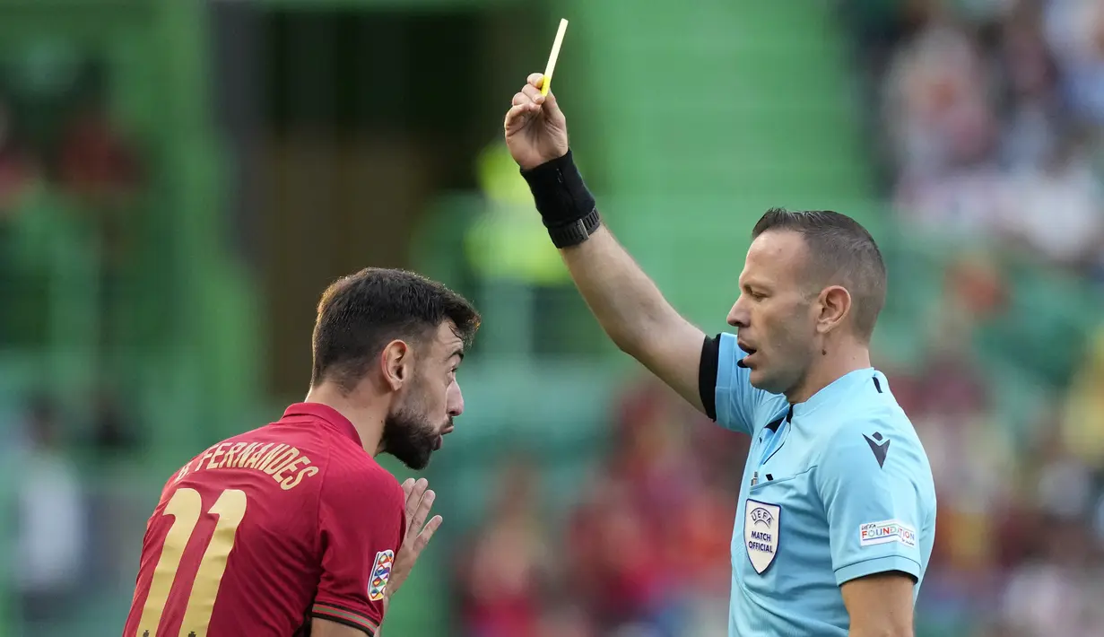Gelandang Portugal, Bruno Fernandes mendapatkan kartu kuning dari Wasit Orel Grinfeeld saat bertanding melawan Swiss pada pertandingan kedua Grup A2 UEFA Nations League di Stadion Jose Alvalade di Lisbon, Senin (6/6/2022). Portugal menang telak atas Swiss 4-0. (AP Photo/Armando Franca)