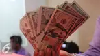 Petugas menunjukkan uang pecahan US$100 di penukaran uang, Jakarta, Rabu (23/9/2015). Mata uang Rupiah  sempat melemah ke level 14.655 per dolar AS pada perdagangan pukul 09.50 waktu Jakarta. (Liputan6.com/Angga Yuniar)